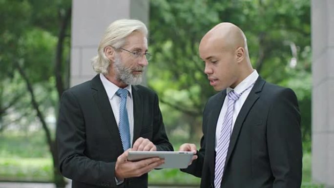两名商人讨论使用数字平板电脑的业务