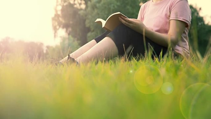 妇女坐在草地上读书