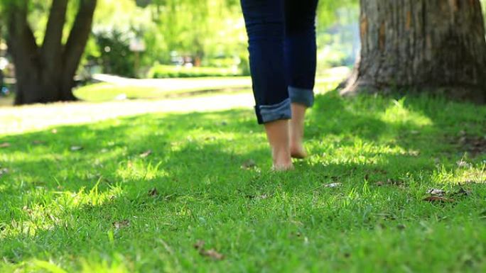赤脚走在草地上的女人