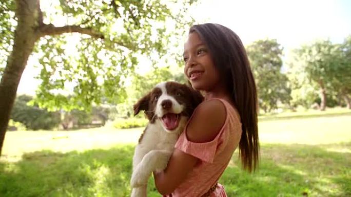可爱的年轻非洲裔美国长发黑发女孩拥抱小狗