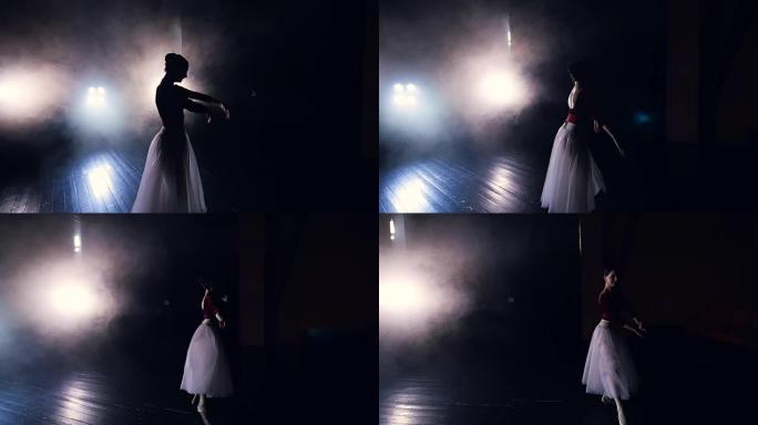 一个跳舞的芭蕾舞演员从黑暗中出来。