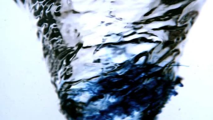 蓝色墨水在白色背景上旋转成漩涡状