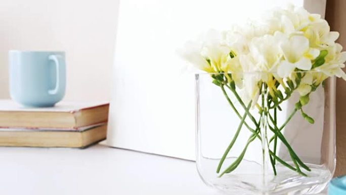 一叠书、空白板、花瓶、一杯茶和台灯