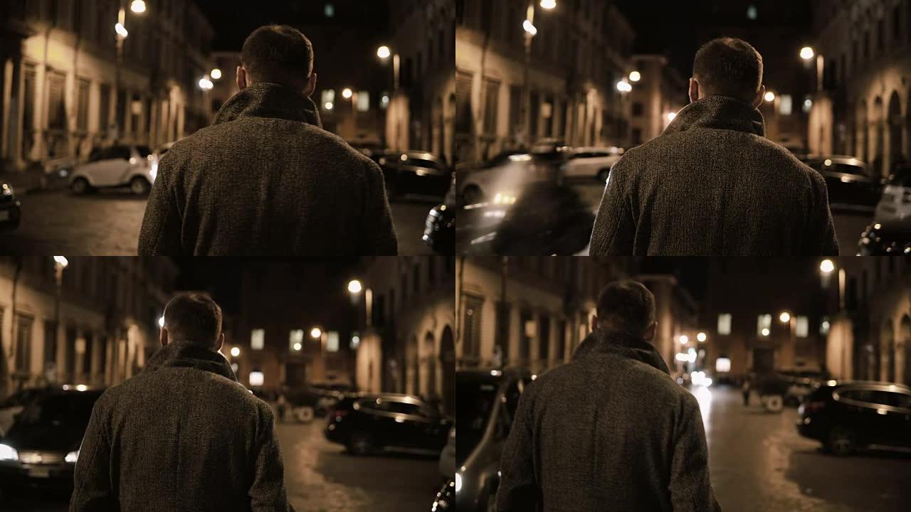 年轻的时尚男人深夜穿过黑暗的街道，晚上独自一人走