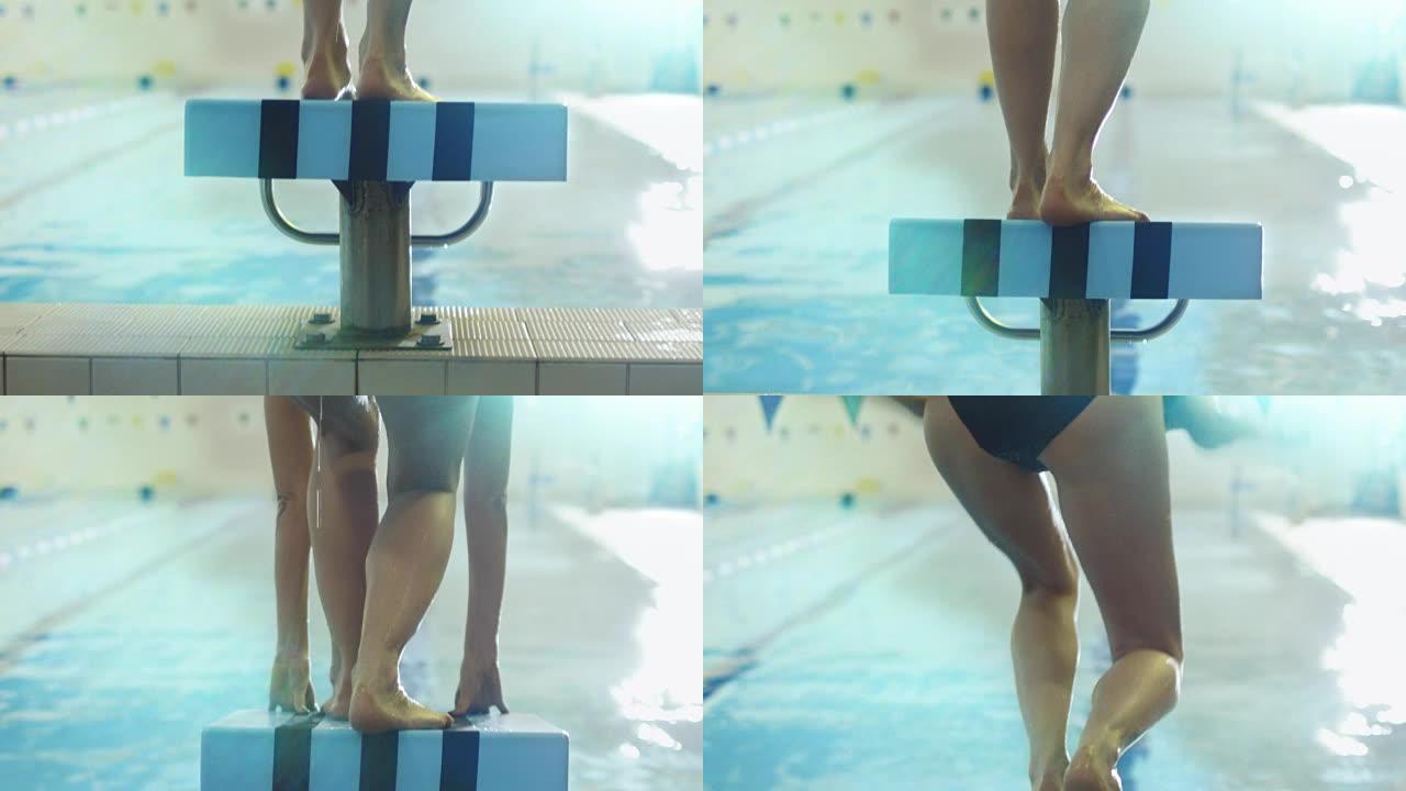 Jib从专业女游泳运动员的背面射击，准备并从起跑器跳入游泳池。