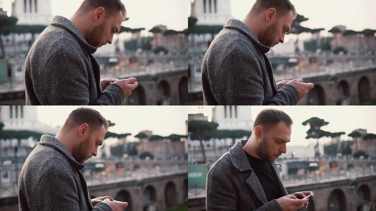 时尚的男人站在意大利罗马市中心。英俊的男性使用智能手机，浏览互联网
