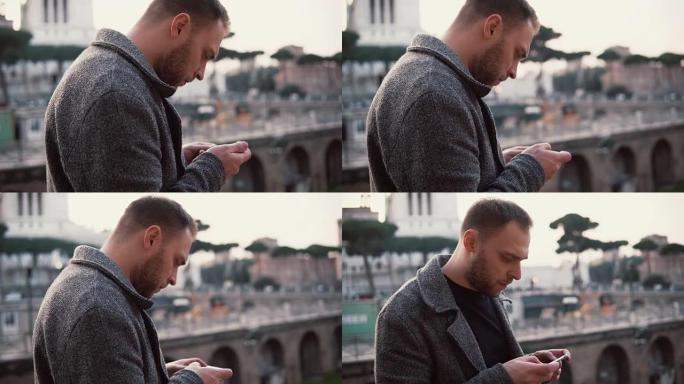 时尚的男人站在意大利罗马市中心。英俊的男性使用智能手机，浏览互联网