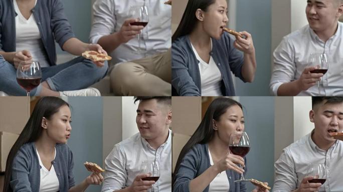 夫妇吃披萨和喝红酒