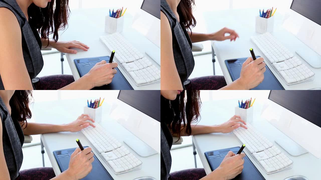 平面设计师在她的办公桌上处理数字化仪
