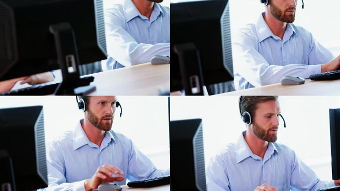 戴着耳机在电脑上工作的男性高管