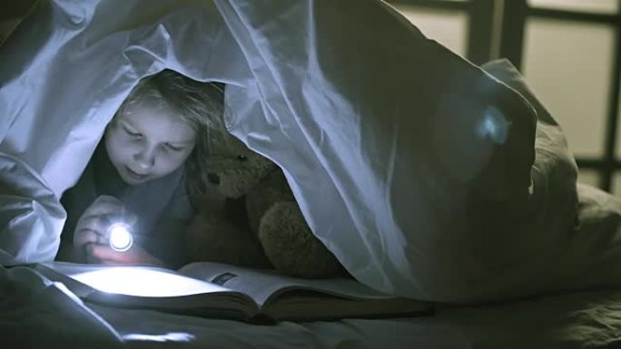 女孩在毯子下看书