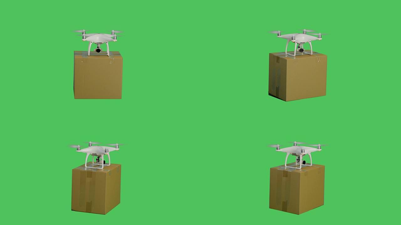 无人机飞行递送邮件纸板箱的顶部照片。背景是绿色屏幕。