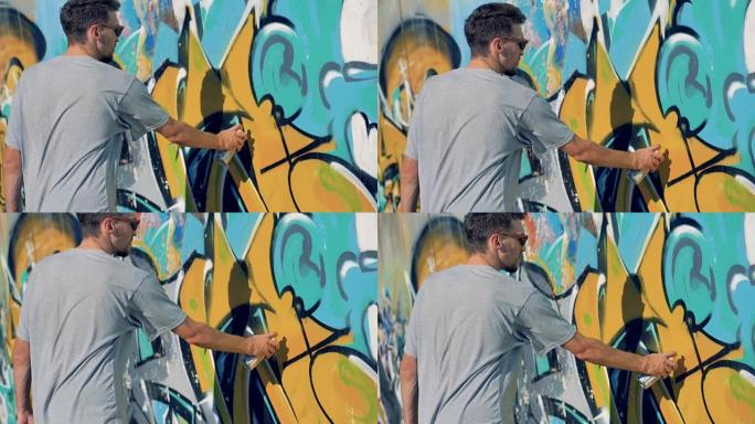 一位男艺术家重新粉刷了一面旧的涂鸦墙。