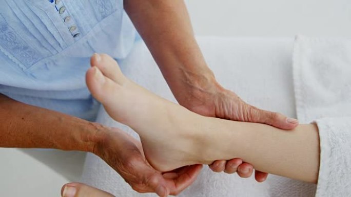女性治疗师按摩病人的脚的特写
