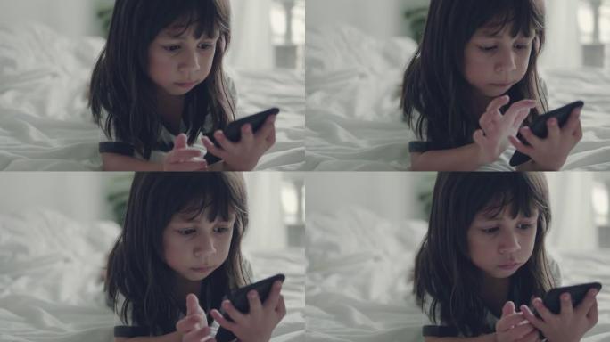 小女孩在家里玩和摸手机。