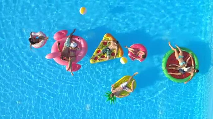 空中: 嬉戏的人在有趣的充气漂浮物上享受暑假