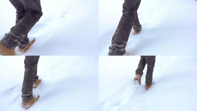 穿着靴子走路的脚在慢动作的冬季景观上，在山上的冬季散步，度假旅游，飘雪