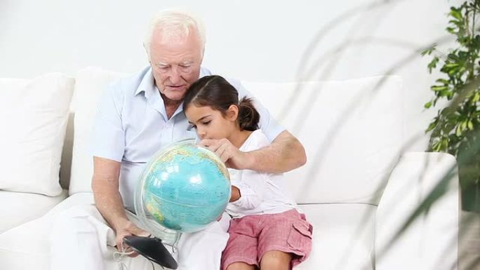 祖父和孙女看着地球仪