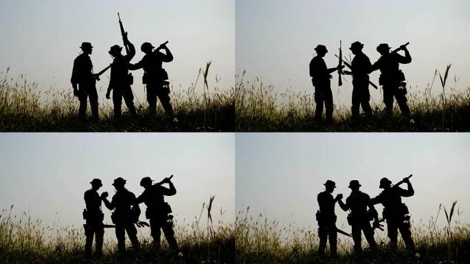 战争结束后，三个全副武装的士兵站在战场上的剪影。