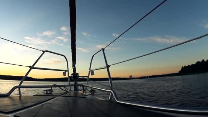 日落时美丽的水景。船的鼻子部分，帆船溅起波浪
