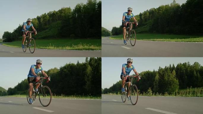 低角度: 在大自然中训练的男性公路自行车手赶上并超越了相机。