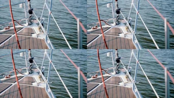 帆船鼻部的特写镜头穿过水面。晴天在公海风中航行