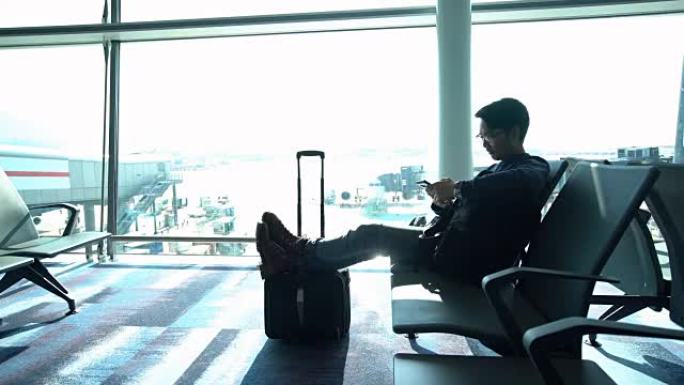 男子在登机口等候登机时使用手机