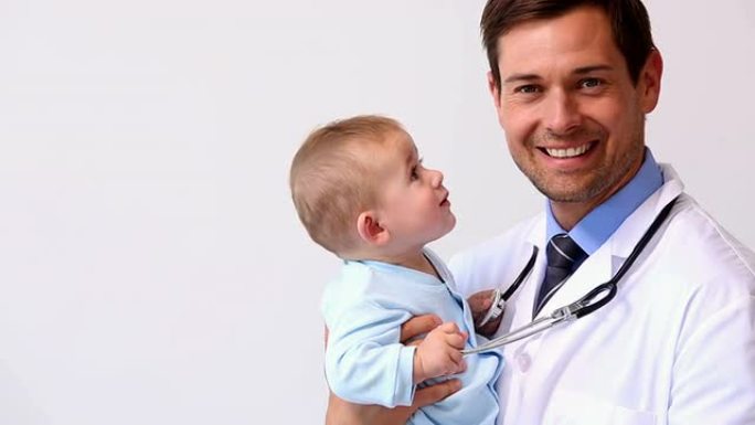 英俊的儿科医生抱着男婴