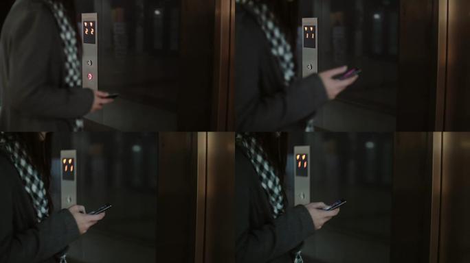 女人按下电梯里的按钮，然后等待。女性站在办公室并使用智能手机，触摸屏幕