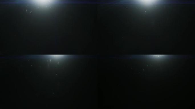 散焦的Bokeh粒子在黑色背景上的光线中缓慢移动。变形的真实镜头光斑，易于在混合/叠加模式下使用。