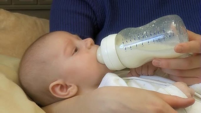 婴儿喝奶瓶里的牛奶