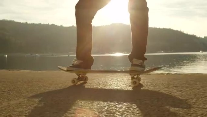 慢动作特写: 滑冰者在日落时在空中跳跃旋转滑板