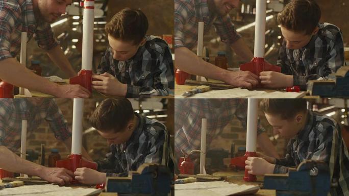 父亲和儿子正在家里的车库里为玩具火箭建模。