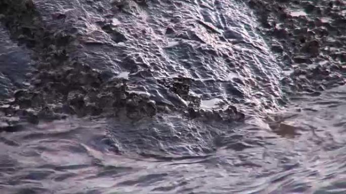强大的波浪冲过危险的岩石，使慢动作接近。