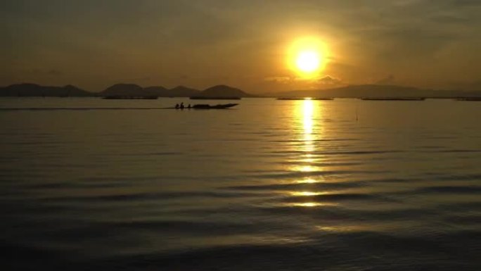 泰国合艾湖里日出时渔夫船的4k跟踪镜头。