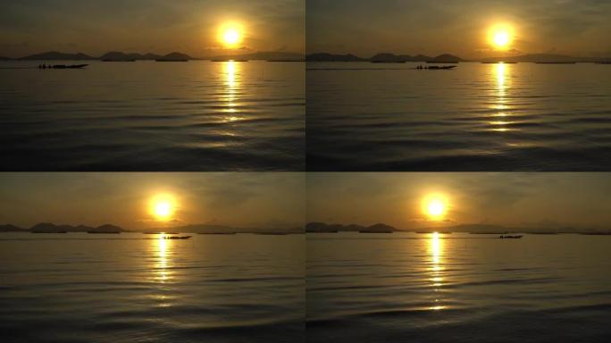 泰国合艾湖里日出时渔夫船的4k跟踪镜头。
