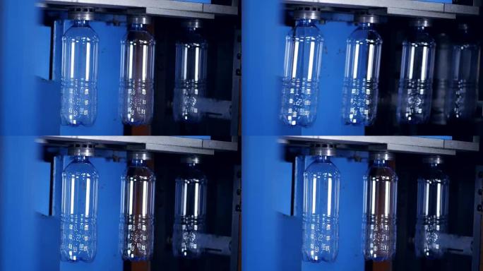 透明的pet瓶瓶坯缓慢移动，后面有发光的光。4K。