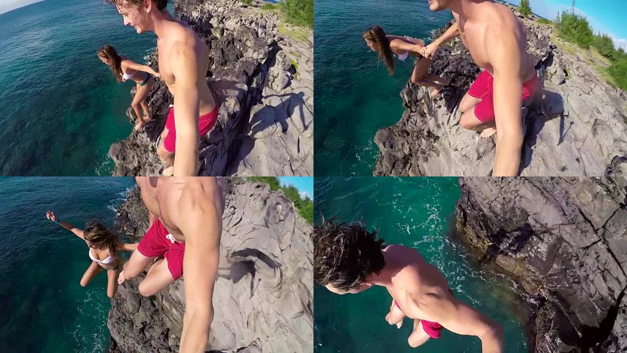 POV慢动作悬崖跳跃。体格健壮的年轻夫妇牵着手从悬崖跳到大海。
