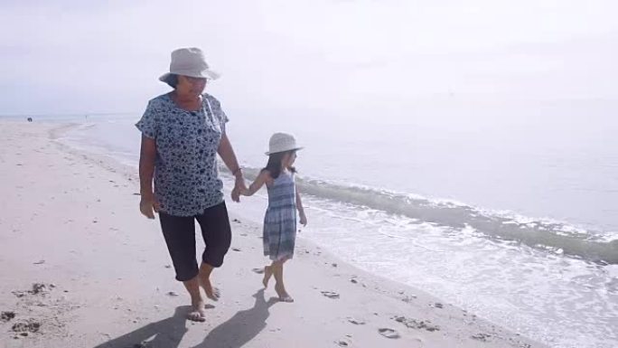 亚洲祖母和孙女在海滩上放松