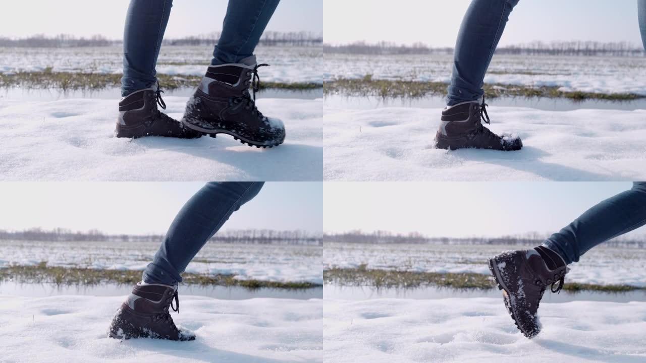 穿着靴子的徒步旅行者在阳光明媚的雪地里行走，超级慢动作