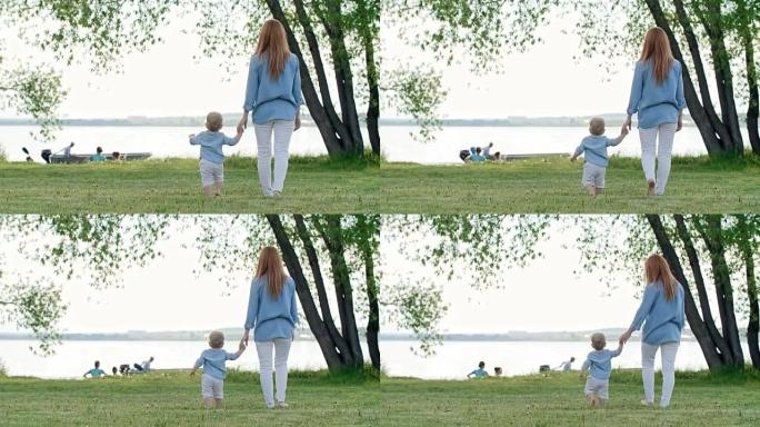 母亲和蹒跚学步的孩子在湖上看船