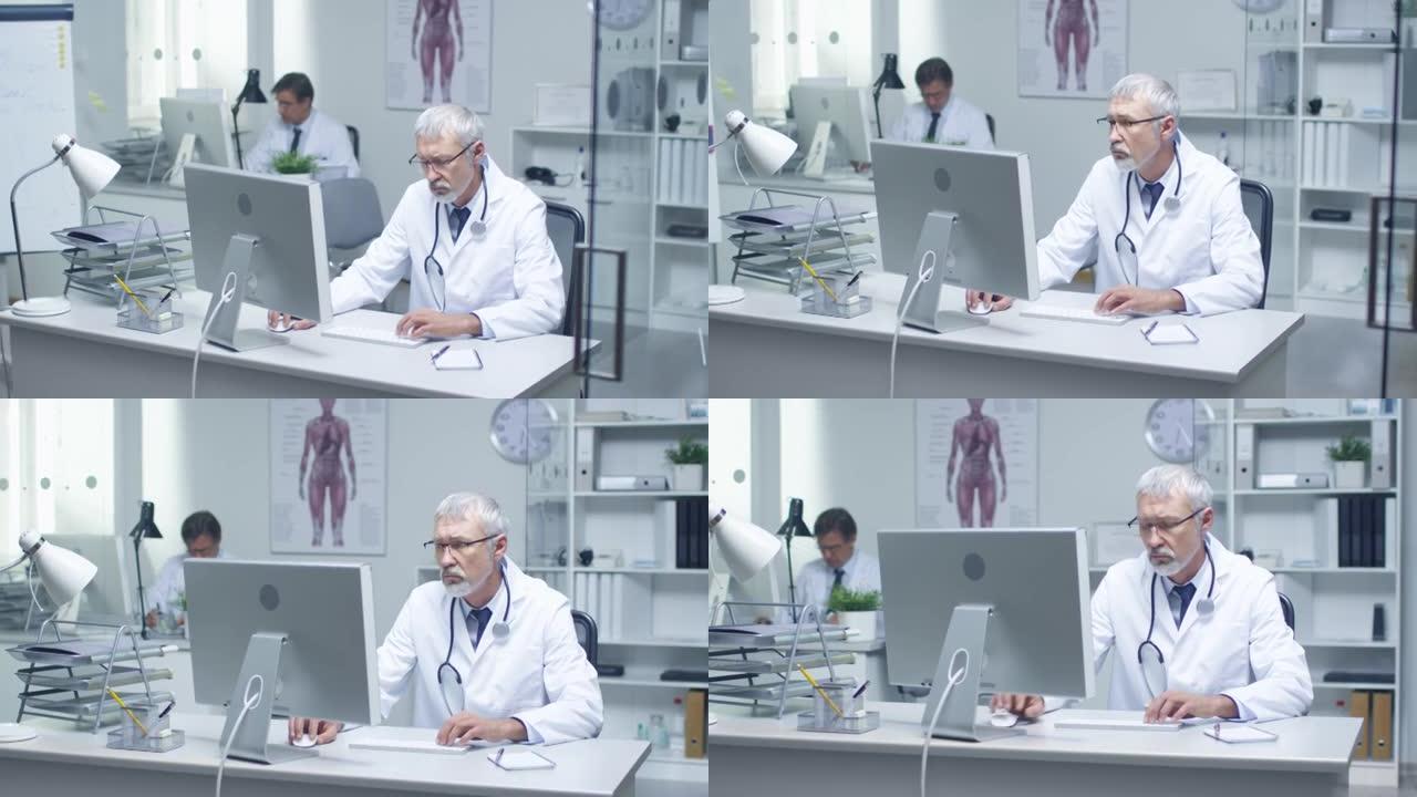 一位白发苍苍的高级医生和他在台式电脑工作的助手的特写镜头。坐在灯火通明的办公室里。
