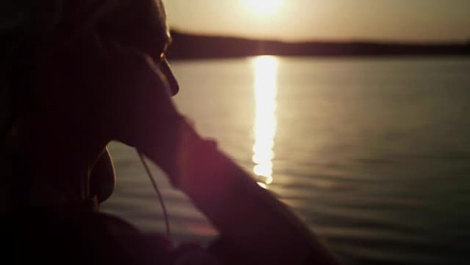 夏季放松。在湖码头上听音乐
