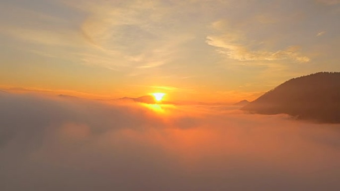 空中: 美丽的金色日落太阳在雾蒙蒙的云层上落下