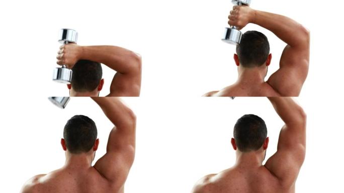 肌肉发达的健美运动员将哑铃举过头顶