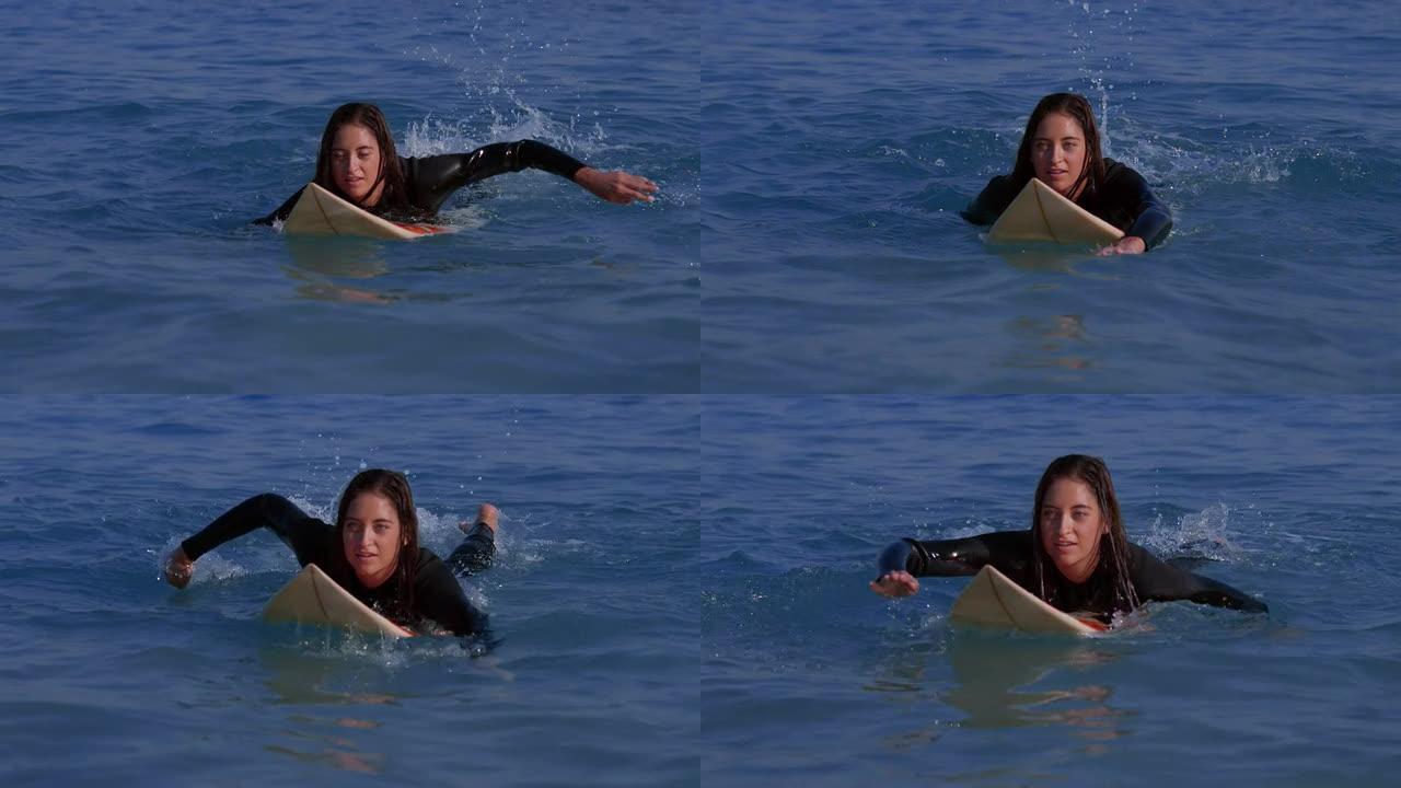 漂亮女人在冲浪板上划水