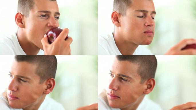 一个年轻人正在吃苹果，目光移开