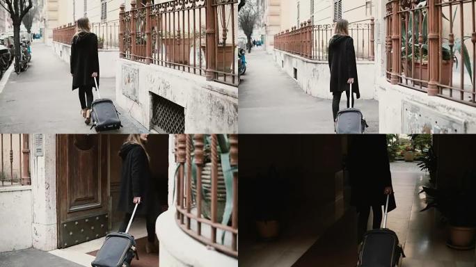 带手提箱走在街上的迷人女人的后景。女商人正在穿过拱门