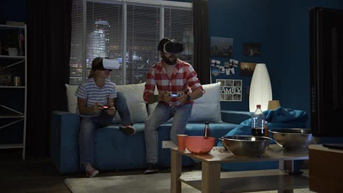 情侣在沙发上玩VR护目镜游戏