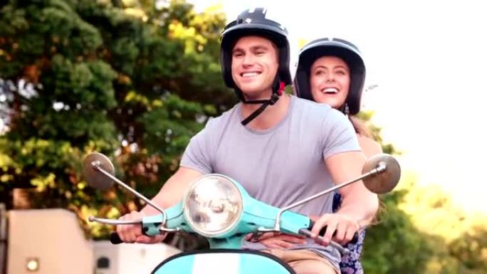 微笑的夫妇骑着踏板车去公路旅行